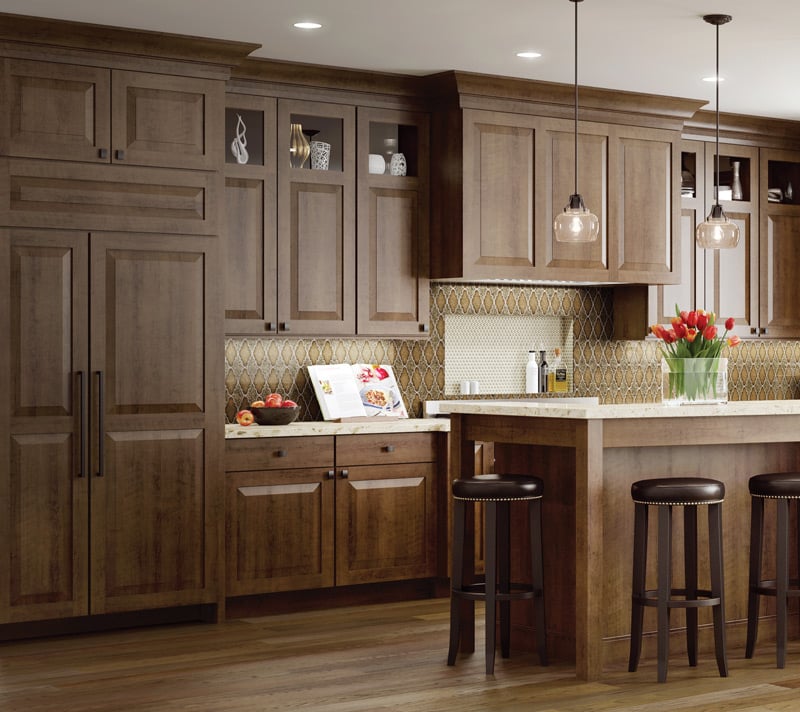 Image shows transitional kitchen style of Woodland Cabinetry with Cherry Stained Galveston style cabinetry doors